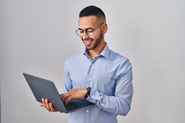 Young hispanic man working using computer laptop with a happy and cool smile on face. lucky person.