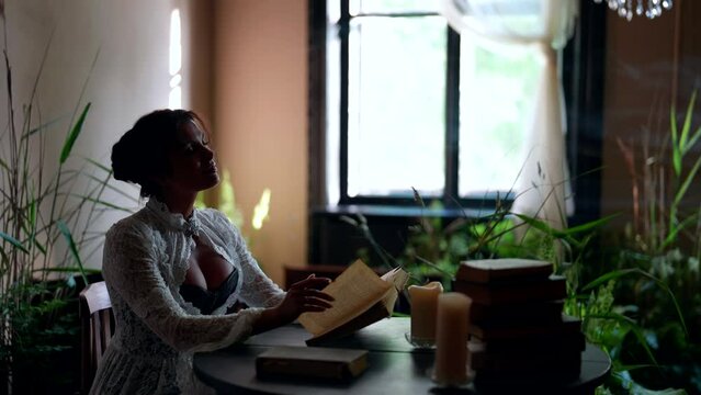 dreamy beautiful woman is sitting in old house and reading book, historic and vintage atmosphere