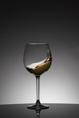 Wave of white wine inside a glass. Moving liquid. Celebration drink concept.