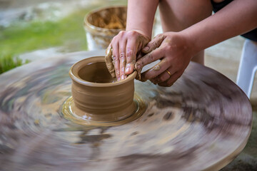 CHAMPA WOMAN WORKING ON POTTERS WHEEL MAKING CERAMIC POT FROM CLAY IN POTTERY WORKSHOP. ART CONCEPT, NINH THUAN, VIETNAM