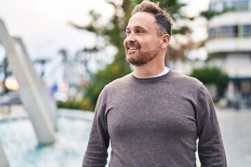 Young caucasian man smiling confident looking to the side at park