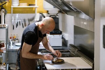man in the kitchen preparing a gourmet mini burgher