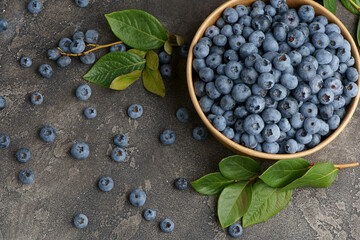 Fresh blueberries with water drops in a wooden bowl. View from above. The concept of healthy and diet food