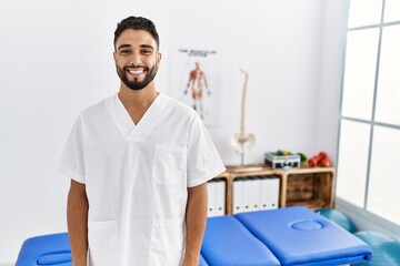 Obraz premium Young handsome man with beard working at pain recovery clinic with a happy and cool smile on face. lucky person.