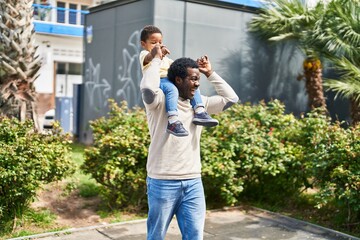 Father and son holding boy on shoulders at playground