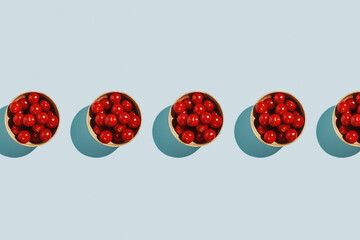 Fototapeta premium Cherry tomatoes in bamboo bowl on pastel blue