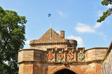 Decorated Entrance to Old Stone Castle with Flag and Blue Sky 