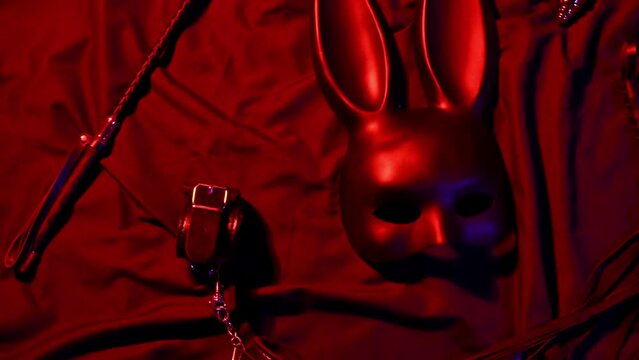 Handcuffs, leather whip flogger, mask and choker for BDSM sex with submission and domination. Concept of erotic adult sex toys