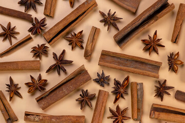 background with cinnamon sticks and anise stars on a beige background, cozy food, spicy trendy background