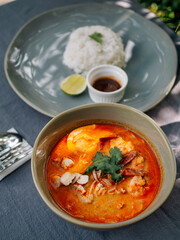 Asian soup 'Laksa' under palm tree at sunny day