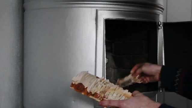 People ripping birch bark to fireplace. Norwegian style sweeter. Steady energy crisis footage. Save oil and electricity.