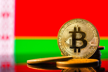 Gold metal coin Bitcoin on the background of the flag of   Belarus . Concept for investors in...
