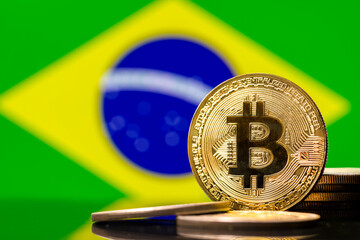  Gold metal coin Bitcoin on the background of the flag of Brazil  . Concept for investors in...