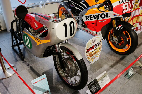 TOKYO, JAPAN - October 20, 2019: A 1961 Honda RA162 racing motorcycle on display next to a modern RC231V inside a Honda showroom in Tokyo.