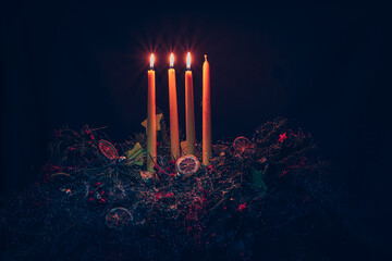 three advent candles burning on advent wreath