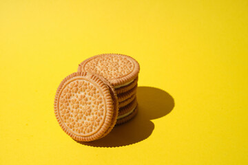 Round cookie with filling on a wooden table.  Sweet cookies on bright background.