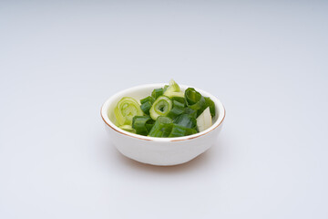 Green onion being trimmed on a white background