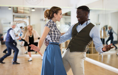 Woman with african man practising charleston dancing
