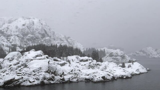 Snow storm at the entrance of the famous Trollfjord (Trollfjorden), Hadsel, Nordland, Norway. The fjord has an extremely narrow entrance and it is surrounded by steep mountains. 