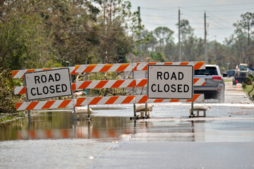 Road closed for roadworks and danger of flooding with warning signs blocking driving of cars