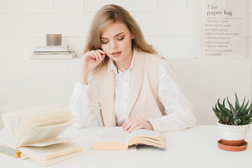 Beautiful business lady sitting at the table with a book