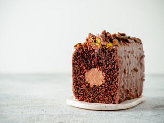 Travel Cake or Tube Cake or Voyage Cake filled center tube ganache and topped chocolate icing and pistachio. Chocolate loaf cake with chocolate cream-cheeese filled center. Copy space