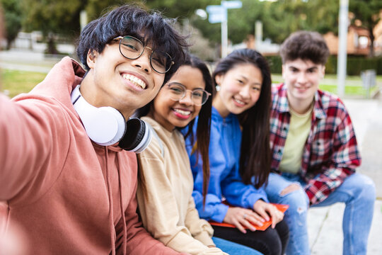 International group of young students taking selfie portrait together with smart mobile phone at college campus university -