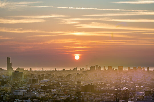 美しい空と太陽で霞む大都会のイメージ写真