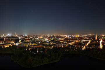 Fototapeta na wymiar Night Copenhagen with bright streets and buildings. View from above. Panoramic view of the night city.