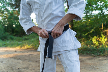 A young man doing karate in the forest training strength pose meditation 