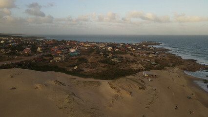 Drone flying over Punta Del Diablo village with picturesque colorful houses, Uruguay. Aerial panoramic view