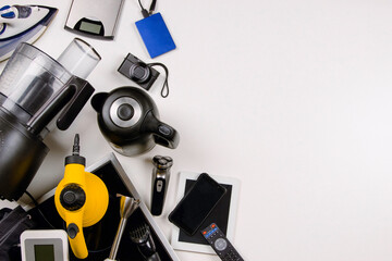 Old household, electrical appliances, broken computers, tablets, phones, used electronic gadgets devices on white background. Top view. Electronic waste for recycling, planned obsolescence concept