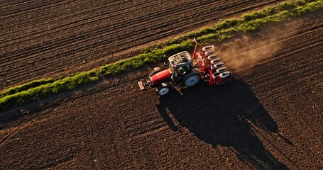 Farmer in tractor seeding soybeans at industrial farm