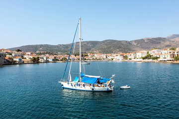 Galaxidi Greece. Sailboat anchored, traditional waterfront houses background.