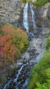 Flying up towards Bridal Veil Falls during Fall in Utah rising up towards the cliffs in Provo Canyon vertical.