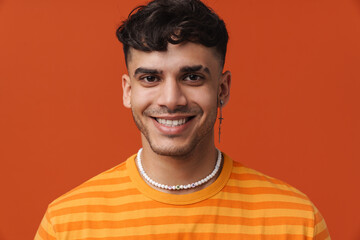 Fototapeta premium Young handsome stylish happy smiling man with piercing in necklace