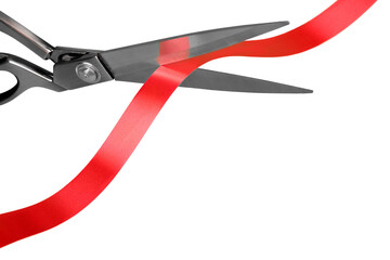 Scissors cutting red ribbon, close-up view on white background