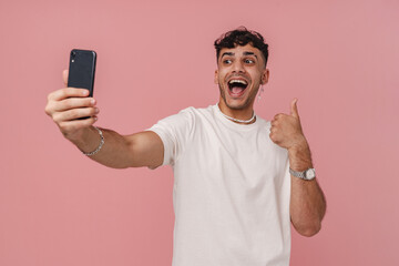 Obraz na płótnie Canvas Young stylish man with opened mouth taking selfie with phone