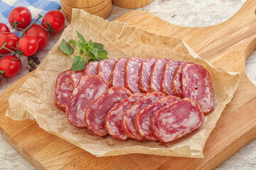 Sliced salami sausages over board