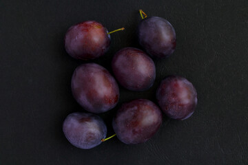 Ripe juicy plum on dark background. Top view