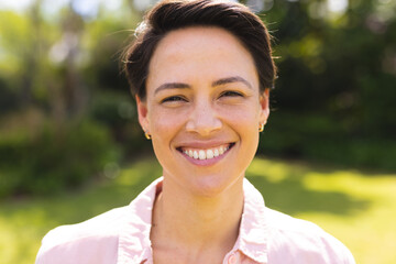 Portrait of young caucasian women wearing blue shirt and standing in the garden