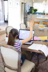 Caucasian girl learning and using laptop with copy space and headphones in living room