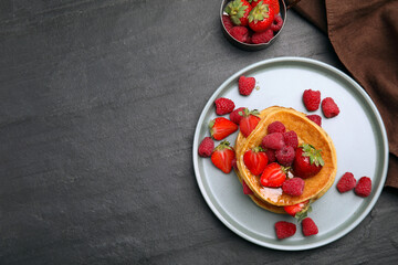 Fototapeta na wymiar Tasty pancakes served with honey and berries on black table, flat lay. Space for text