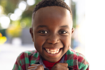Happy smiling african american boy welcoming somebody outside the house