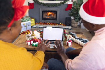 African american couple having face time and using laptop with copy space