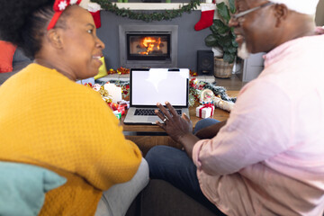 African american couple having face time and using laptop with copy space