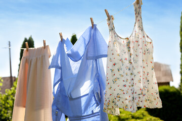 Clean clothes hanging on washing line in garden. Drying laundry