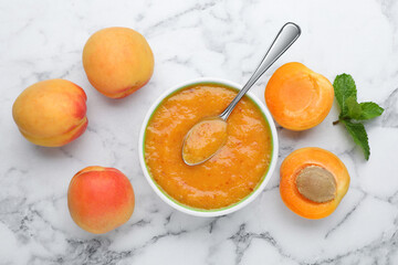 Apricot puree in bowl and fresh fruits with mint on white marble table, flat lay