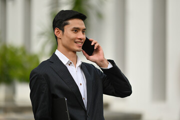 Smart Businessman talking on phone while out of the office.
