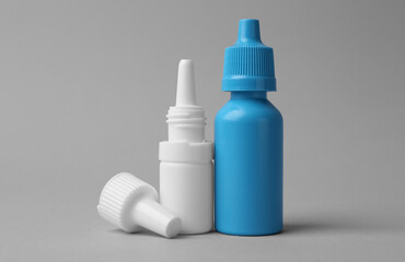 Bottles of medical drops on grey background